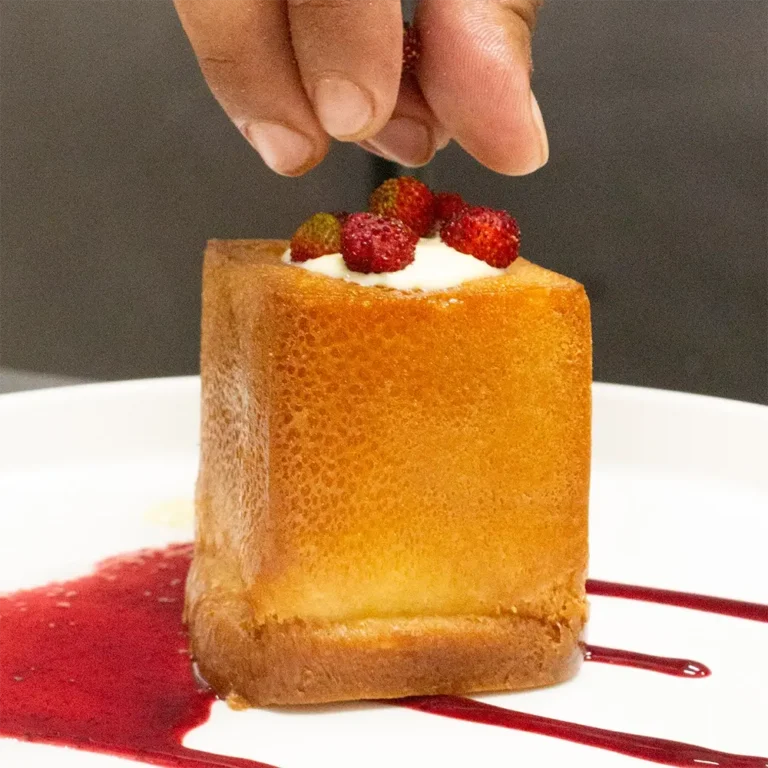 Babà napoletano con crema e fragoline di bosco su salsa ai frutti rossi