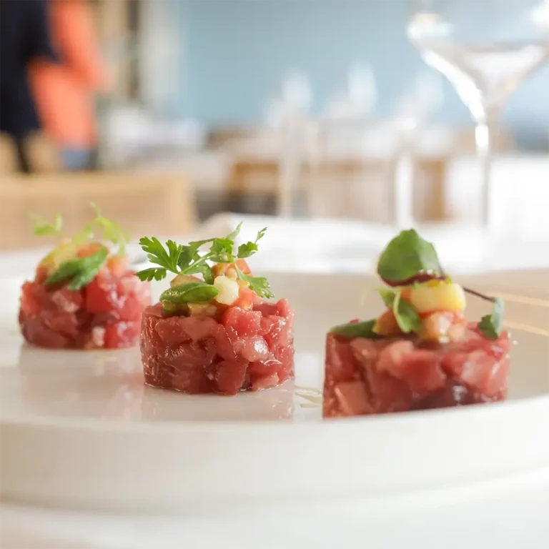 Tre assaggi di crudo di mare serviti su piatto bianco